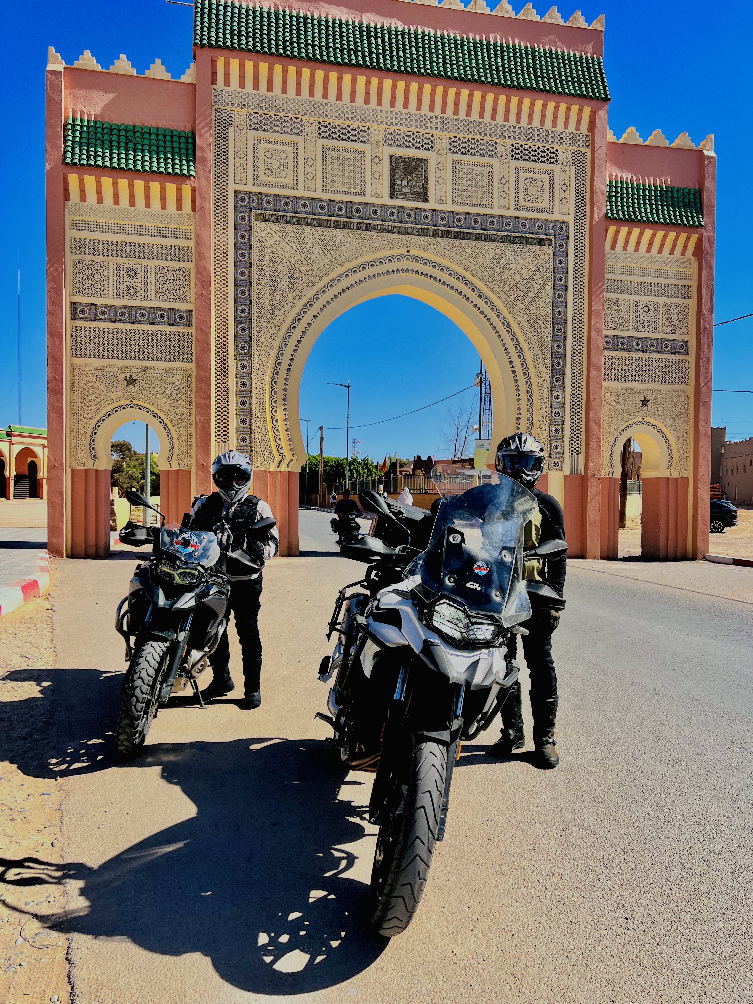 Motorcyclistes devant un monument de Marrakech